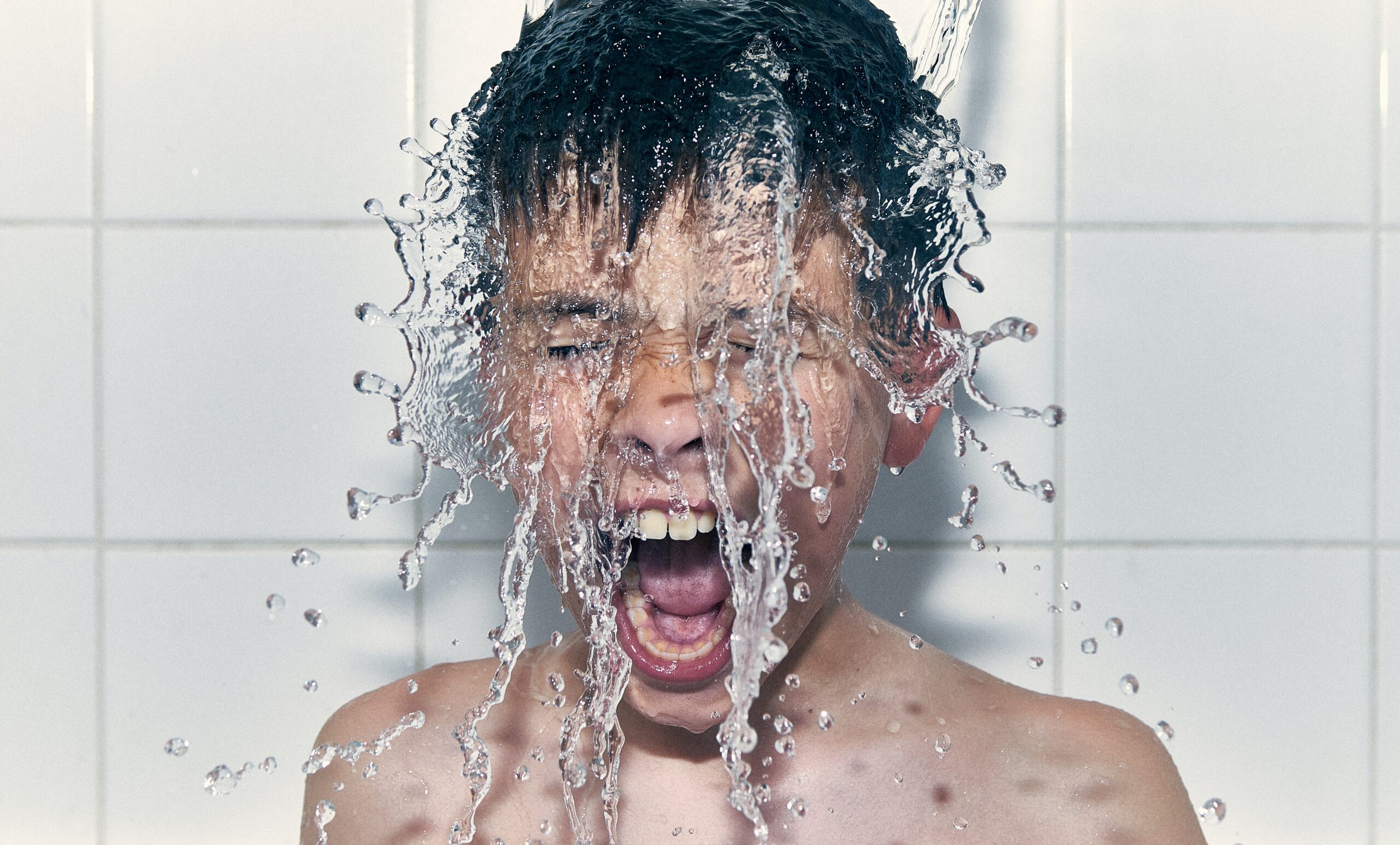 man in bathtub with water droplets