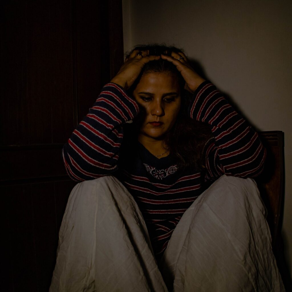 woman in black and red striped long sleeve shirt sitting on chair