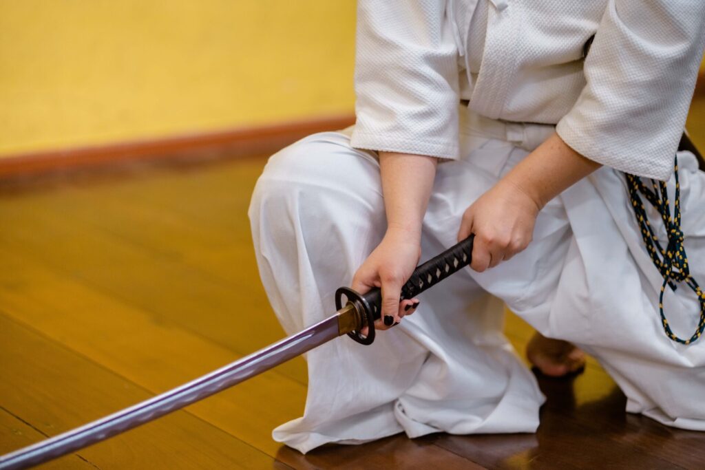 man holding black and gray katana